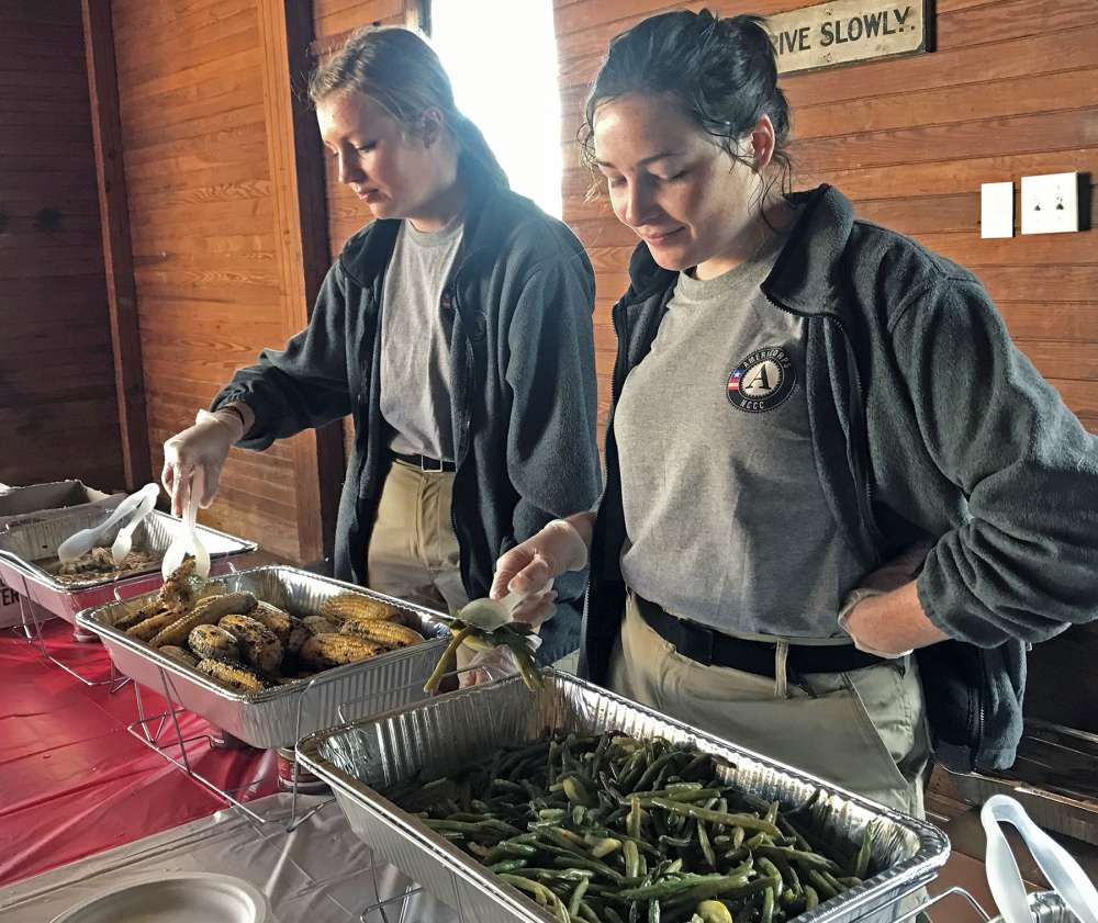 AmeriCorps volunteers prepare to serve... food.
