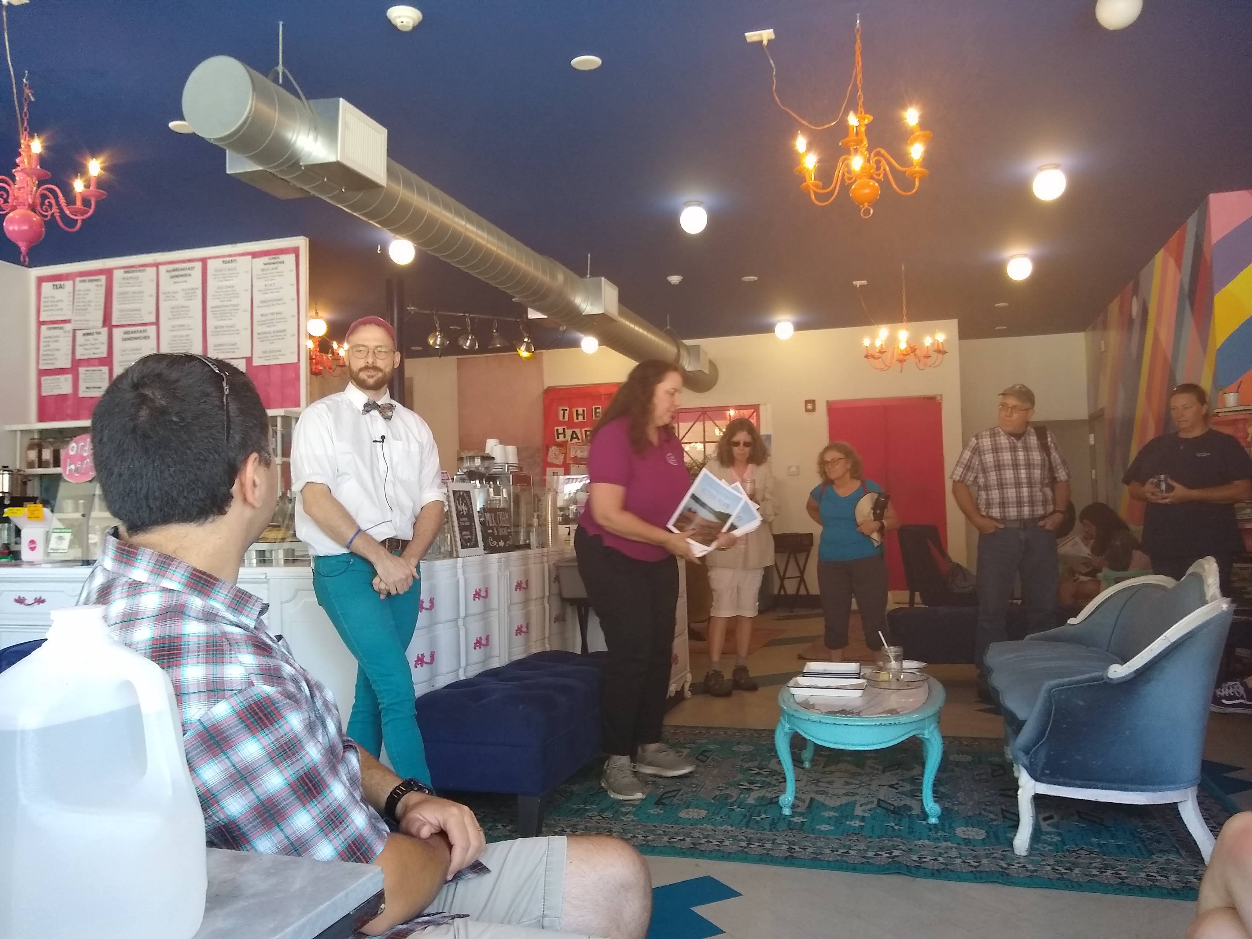 Emmett Soldati talks at Teatotaller Cafe while Kira Jacobs distributes watershed action plans.