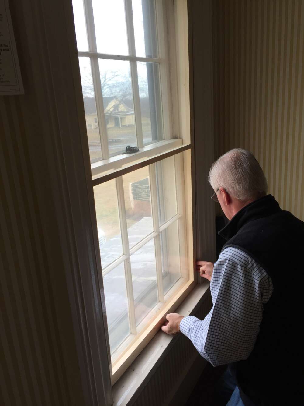 WindowDressers volunteer installs window insert in farmhouse.