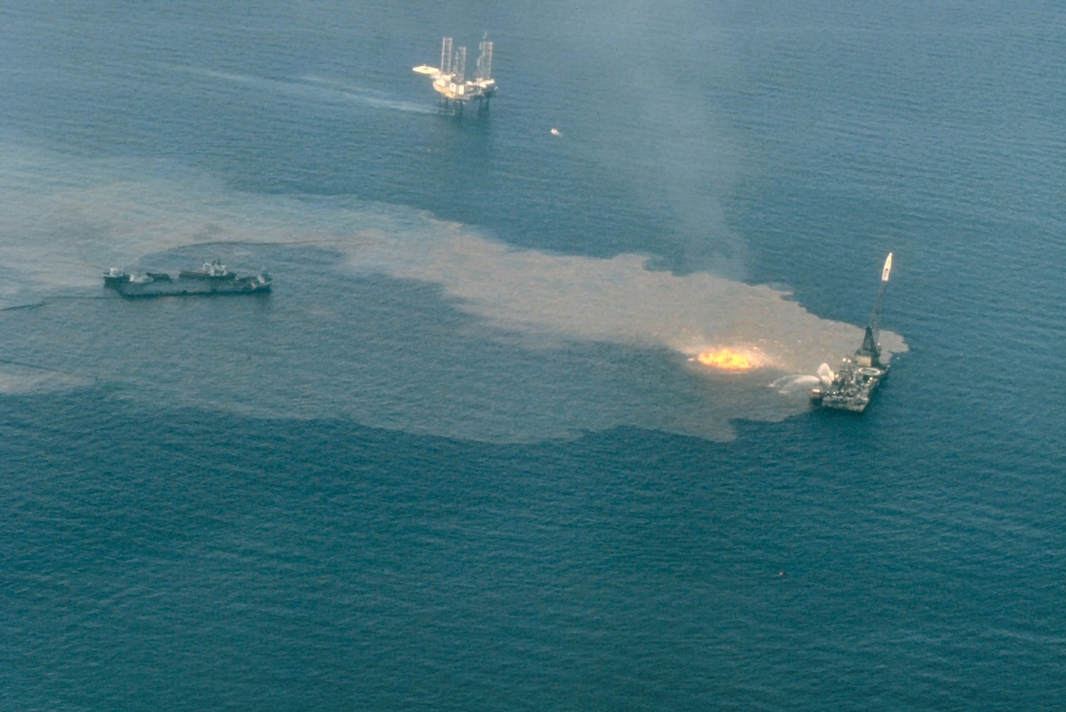 A platform at the site of the Ixtoc-I oil well blowout burns in the Bay of Campeche, Mexico. Public domain image by NOAA.