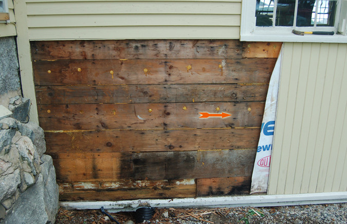 Exposed wall with arrow showing area of detail.